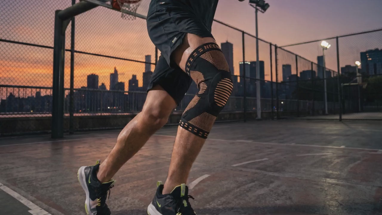 Vidéo : genouillère de compression noire et cuivre au basket, au coucher du soleil